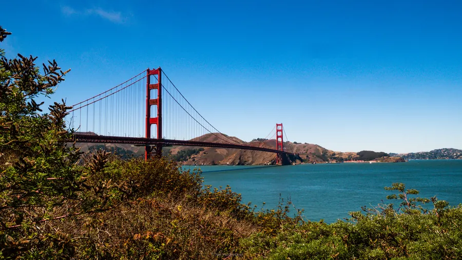 Golden Gate Bridge with blue sky and green hills, San Francisco