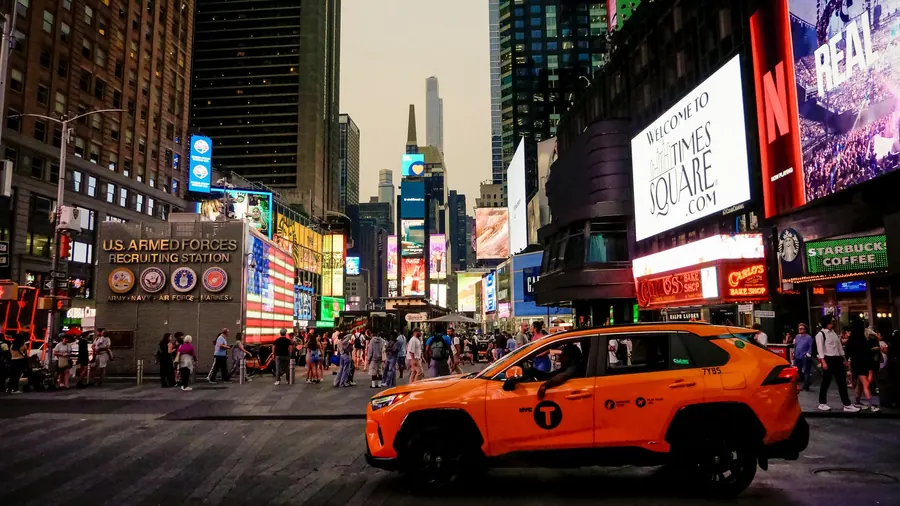 Yellow taxi in front of the billboards on Times Square, New York